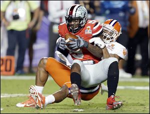 Ohio State quarterback Braxton Miller is brought down by Clemson defensive end Vic Beasley during the first half of the Orange Bowl.
