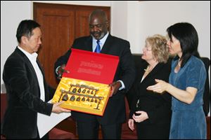 In this 2011 photo, Mayor Mike Bell, center, accepts a gift from Zhao Talimu of Beijing Conservatory. To the mayor’s left is  Kathy Carroll, Toledo Symphony president, and Amy Chang, associate principal cellist.