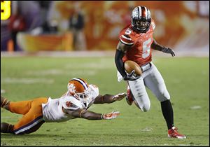 Ohio State quarterback Braxton Miller runs past Clemson’s Robert Smith for a touchdown in the Orange Bowl. He threw for 2,094 yards and ran for 1,068 this season.