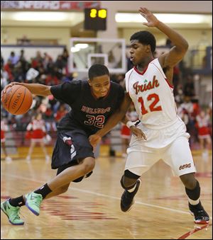 Scott’s Chris Darrington drives against Central Catholic’s Jermiah Braswell  in Saturday night’s game. The Bulldogs won in three overtimes, improving to 4-4. The Irish fell to 8-1.