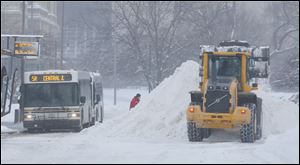 TARTA picks-up passengers on Jackson Street at the same time plows clear the street during a Level 3 snow emergency.