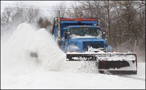 A plow throws snow 