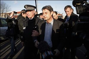 Goodyear's human resources chief, Bernard Glesser, center, and the firm's production manager Michel Dheilly, center right, leave the Goodyear plant in Amiens, northern France, today.