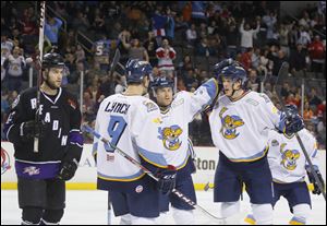 Toledo Walleye players Kevin Lynch (9), Ryan Flanigan (32) and Louis-Marc Aubry (25) celebrate Aubry's game winning goal against Reading Royals during the third period at the Huntington Center, Friday, Jan. 3, 2014.