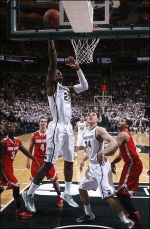 Michigan State's Branden Dawson (22) lays the ball up as Ohio State's Shanon Scott (3), Aaron Craft (4), and LaQuinton Ross, right, and Michigan State's Gavin Schilling (34) watch during the first half of an NCAA college basketball game, Tuesday, Jan. 7, 2014, in East Lansing, Mich.