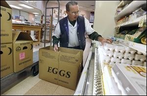 Rick Garner restocks eggs at Walt Churchill's Market in Perrysburg on. Retailers, whose deliveries of food and produce were disrupted by bad weather and travel bans, scramble to restock.