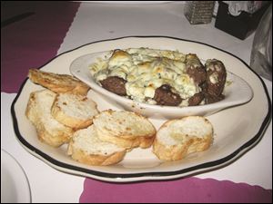 Beef tips with melted blue cheese and toasted bread rounds.