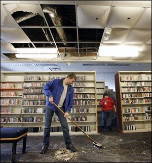 Patrick Richardson of Polygon cleans up damage at the  Heather-downs branch of the Toledo-Lucas County Public Library. Water covered much of the floor after the cold caused a pipe to burst.