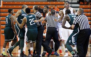 Officials break up a skirmish between Bowling Green and  Eastern Michigan players in Wednesday night’s MAC opener.