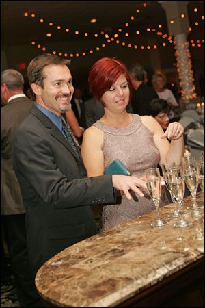 Andy and Michele Kress contemplate which glass to select. Guests at the Central Catholic High School fund-raiser could purchase a glass of champagne that contained a 1-carat cubic zirconia, but one held a 1-carat diamond.