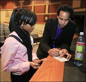 Woodward High junior Lyric Carter, left, speaks with David Johns after his talk at the school.