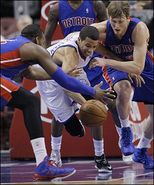 The Pistons’ Greg Monroe, left, and Kyle Singler, right, scramble for a loose ball against the 76ers’ Michael Carter Williams. Singler had 16 points and Monroe added 15.