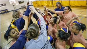 UT head coach Tricia Cullop shows the girls how to cheer in a huddle during Girls Basketball Skills Camp at the University of Toledo’s Health Education Center. 
