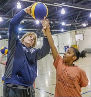 Rockets basketball head coach Tricia Cullop shows Janet Whitney proper shooting form during Girls Basketball Skills Camp. Ms. Cullop, who volunteered her time, says helping the community is a ‘win-win.’ 