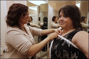 Brittni Mominee measures Paula Swan for a bra at Dillards at Franklin Park Mall.