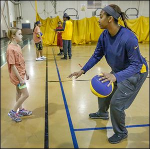Emma Gall gets dribbling lessons from UT player Mariah Carson during Saturday’s Basketball Skills Camp. The Saturday camp is sponsored by the Toledo Community Recreation Program.