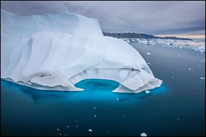 An iceberg melts off the coast of Greenland. The Arctic has less than half the sea ice it did 50 years ago each September, the most critical month there because it’s the end of the summer thaw and the beginning of the refreezing period.
