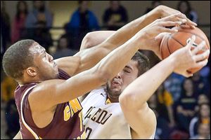Toledo's Nathan Boothe struggles to keep control of the ball under defensive pressure from Central Michigan's Chris Fowler.