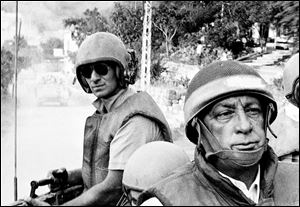 Israeli Defense Minister Ariel Sharon, foreground, rides an armored personnel carrier on a tour of Israeli units advancing to the outskirts of Beirut, Lebanon, during the Israeli occupation in this 1982 file photo.