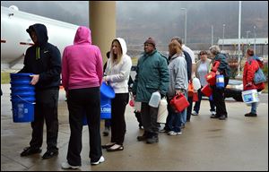 People wait in line for water from a 7,500-gallon tanker truck brought in from Washington, Pa.