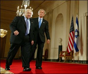 President George W. Bush, right, and Israeli Prime Minister Ariel Sharon, left, walk together at the end of a joint press conference in the Cross Hall of the White House in Washington in this 2004 file photo.