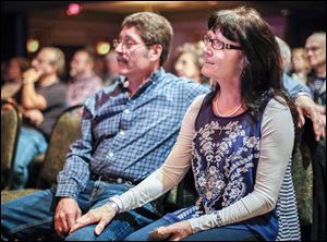 Tom and Patty Biller of Findlay listen as Idletyme performs at the Holiday Inn French Quarter in Perrysburg at the annual bluegrass festival. Organizers say the festival usually sells out of its 500 tickets per day as it draws music lovers and bluegrass bands from all over.