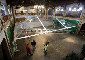 Workers erect a clear tent in the Great Hall of the zoo’s Museum of Science to prepare for the zoo’s first indoor butterfly exhibit that begins on Friday.