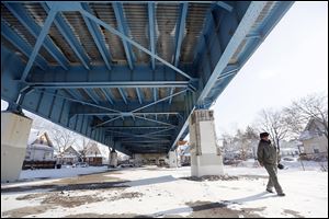 John Whitlow, outreach technician, looks around the Anthony Wayne Bridge for homeless people who need food and shelter in order to bring them to a safe place.