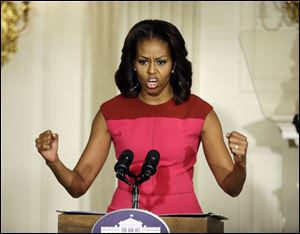 First lady Michelle Obama clutches her fists as she speaks at an event to help promote fresh fruit and vegetable consumption to kids in an event in the State Dining Room of the White House in Washington in October.