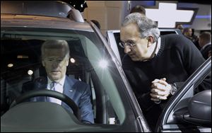 Vice President Biden sits in a Chrysler product and listens to Chrysler-Fiat CEO Sergio Marchionne at the auto show.