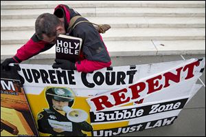 The U.S. Supreme Court heard arguments about buffer zones around abortion clinics. A man from North Carolina makes his point outside the court.