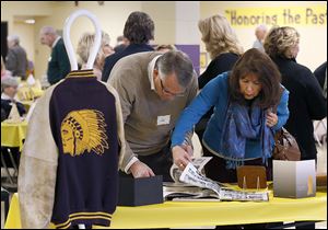 Waite alumnus Jim Ellinger and his wife, Nancy, of Holland glance through yearbooks during the centennial celebration.