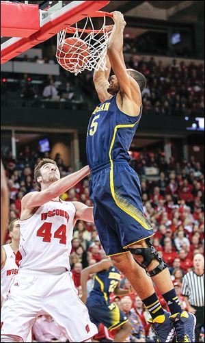 Michigan's Jon Horford, right, dunks over Wisconsin's Frank Kaminsky during the first half of their Big Ten Conference game.