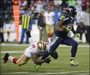 Seahawks running back Marshawn Lynch breaks away from San Francisco 49ers lineman Aldon Smith for a touchdown run during the second half on Sunday in Seattle.
