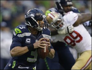Seahawks quarterback Russell Wilson looks to pass during the first half on Sunday.