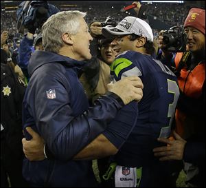 Seahawks coach Pete Carroll celebrates with Russell Wilson after the NFL football NFC championship game on Sunday in Seattle. The Seahawks won 23-17 to advance to Super Bowl XLVIII.