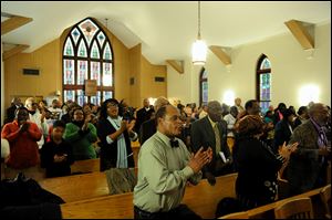 People stand to the feet during the music portion of the Black History Committee's celebration of Dr. Martin Luther King, Jr's birthday at Greater Norris Chapel Baptist Church in Henderson, Ky, Sunday.