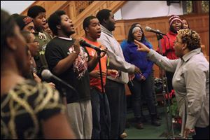 The Toledo Youth Choir tenors, including Ernest Kight II, 19, center left, sing and clap as they follow their director, Antoinette Goodloe, right, during practice at Ebenezer Missionary Baptist Church in West Toledo. The choir is set to perform today at UT’s Savage Arena during Martin Luther King, Jr. Unity Day.
