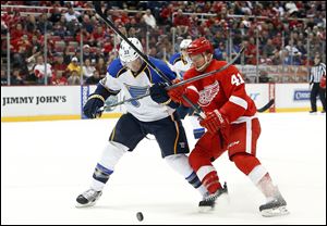St. Louis Blues defenseman Jordan Leopold, left, and Detroit Red Wings wing Luke Glendening (41) battle for the puck in the second period.