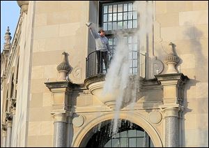 Staff writer David Patch hurls a pot of near-boiling water from the balcony outside a third-floor Blade office while the temperature outdoors hovered at about -3 degrees Wednesday morning.