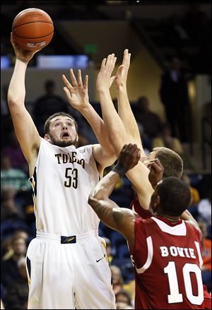Toledo center Nathan Boothe shoots over NIU’s Darrell Bowie on Wednesday. Boothe finished with 10 points and seven rebounds.
