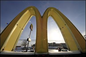 Cars drive past the McDonald's Golden Arches logo at a McDonald's restaurant in Robinson Township, Pa. 