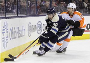Columbus Blue Jackets' Boone Jenner, left, carries the puck as Philadelphia Flyers' Braydon Coburn defends during the second period of an NHL hockey game, today, in Columbus.