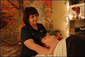 Yvonne Fey, shown massaging Gretchen Mikolajczak of Toledo in her Perrysburg business, moved a step closer to being able to go to an Olympics games.