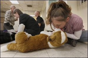 Lucas County Canine Care & Control volunteer Jackie Stephan learns to resuscitate a dog, using a stuffed animal. during the course.