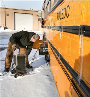 Bert Gilbert of Toledo Public Schools charges bus batteries affected by the cold weather. The weather has forced the district to close repeatedly this year. 