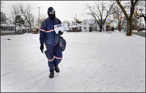 Postal worker Jemael Smith trudges through his rounds in South Toledo. He said, ‘It’s cold but there’s not much you can do about it.’ He advised to bundle up and minimize the skin showing to avoid frostbite. 