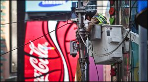 A technician works on a light post where a temporary surveillance camera is installed, Thursday in New York.