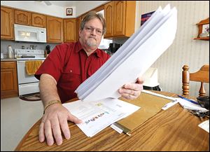 Robert Geis holds a sheaf of job applications in his city home. Mr. Geis, who has been jobless since February, 2013, applies for 15 jobs per week on average. 
