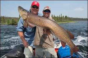 Toledo businessman Don Mewhort, left, with guide Collin Reddekopp, holding a 49-inch northern pike Mr. Mewhort caught in Canada.